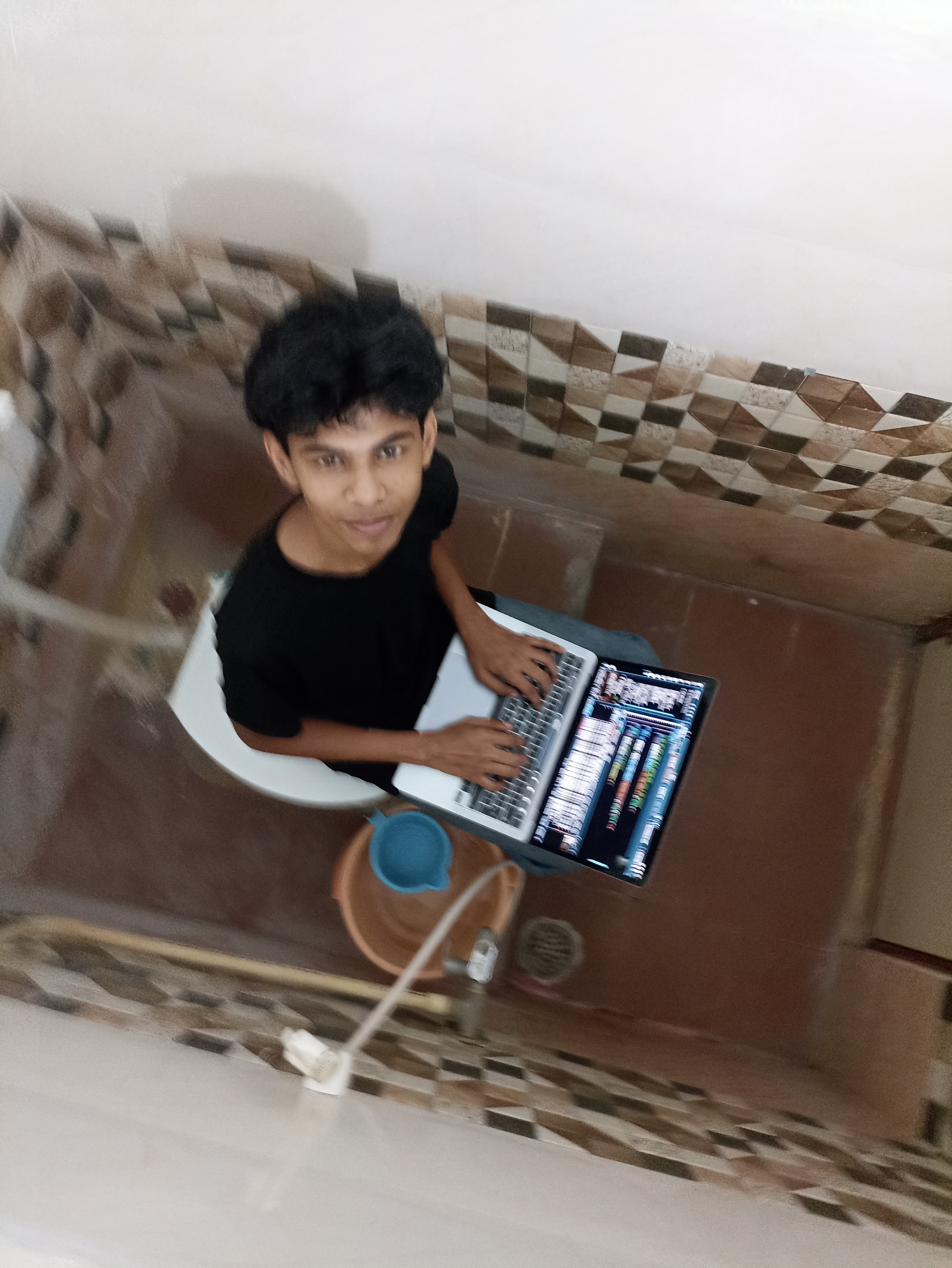 Riza Mohamed coding on a laptop, developer from Kerala, India