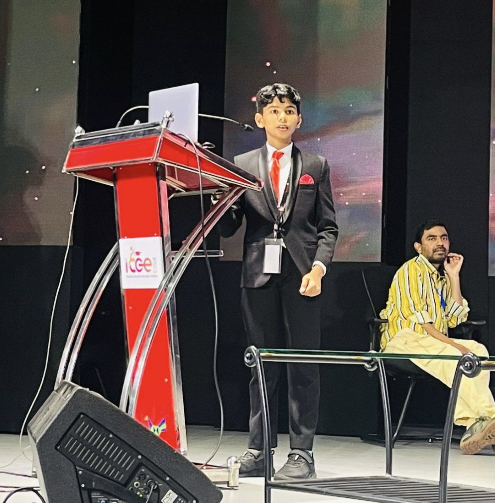 Riza Mohamed at IRCC podium delivering keynote talk