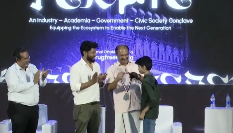 Riza Mohamed receiving award medal on stage tech event Kerala India