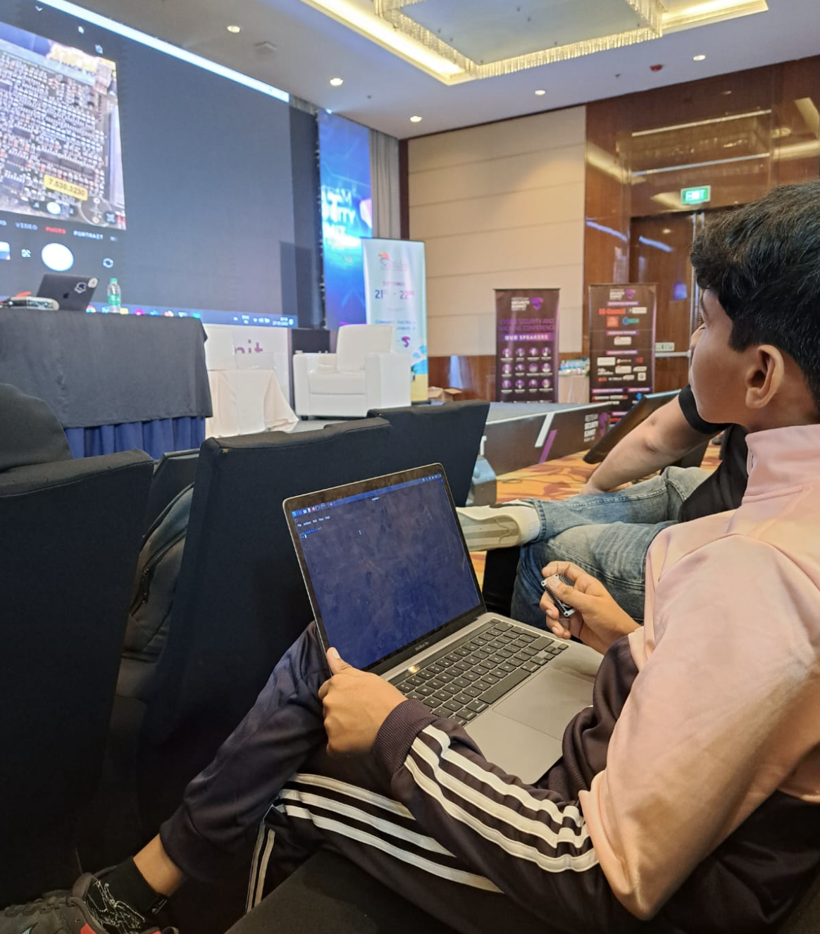 Riza Mohamed coding laptop at NIA conference event